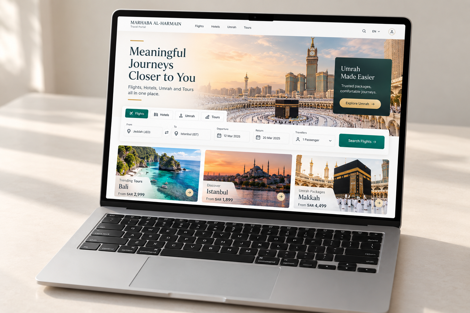 Silver laptop with a visible keyboard displaying a colorful Marhaba Al-Harmain travel portal